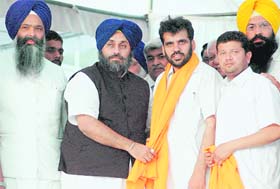 Punjab Deputy Chief Minister Sukhbir Singh Badal presents a siropa to Zirakpur MC president NK Sharma at a rally in Zirakpur