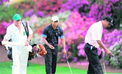 Tiger Woods (centre) of the US and Indias Jeev Milkha Singh (right) prepare for a putt on the thirteenth green during the first round of the US Masters at the Augusta National Golf Club on Thursday.