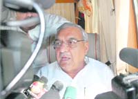 Chief Minister Bhupinder Singh Hooda addresses a press conference on board his specially designed campaign rath