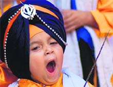 Sleepy Warrior: A kid dressed up as a “Panj Payara” yawns during the nagar kirtan taken out on the eve of Baisakhi in Ludhiana on Saturday.