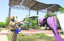 A cop, who has been housed along with 14 other cops at the cremation ground belonging to CM Parkash Singh Badals families at Badal village in Muktsar district, busy in a household chore on Saturday.