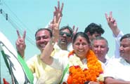 Congress candidate from North West Delhi Krishna Tirath shows the victory sign on way to filing her papers in New Delhi on Monday.