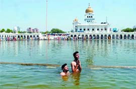 DIVINE DIP: Sikh devotees take a dip in the pond of Bangla Sahib Gurdwara on the occasion of Baisakhi in New Delhi on Monday.