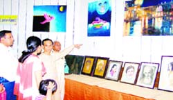Artist Chandra Mani Sharma talks to visitors about his paintings at Town Hall in Haridwar. The exhibition was held to mark Kalangans silver jubilee