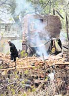 A Kashmiri Muslim walks over the rubble of a residential house destroyed in a gunbattle between the Army and militants in Aglar, 45 km from Srinagar, on Monday. Three houses were destroyed during the gunfight which started on Saturday.