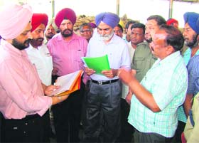 Principal Secretary to Punjab Chief Minister DS Guru (centre) and Patiala Divisional Commissioner Jasbir Singh Bir (third from left) inspect wheat procurement operations at the Sirhind grain market in Patiala