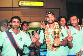 Indian hockey team captain Sandeep Singh with Sultan Azlan Shah field hockey trophy along with Prabhjot Singh (L) and other team mates arrives at IGI Airport in New Delhi