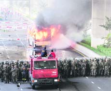 Anti-government protesters and supporters of ousted Prime Minister Thaksin Shinawatra set a bus afire during a protest in Bangkok, Thailand, on Monday.