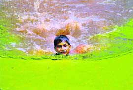 A boy tries to beat the heat by taking a dip in filthy water on the outskirts of Jammu city. 
