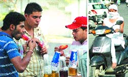 Boys take a bite at their burf golas as a girl uses her duppatta to cover her face on a hot day in Jalandhar. Tribune photos: Pawan Sharma 
