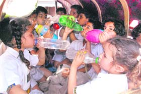Schoolchildren quench their thirst on a hot afternoon in Gurgaon