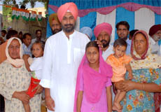 Raninder Singh with the family members of slain Congress workers in Ghasso Khana village. 