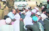 Rajaji Park director SS Raisaily talks to Van Gujjars outside his office in Dehradun on Thursday. 