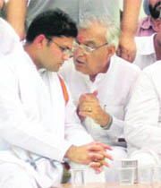 Chief Minister Bhupinder Singh Hooda discusses a point with Congress nominee Ashok Tanwar in Sirsa on Thursday.
