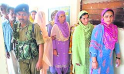 Voters await their turn outside a polling booth at Sidhra (Jammu)