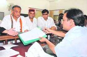 Vijay Bahuguna (left) files his nomination in Dehradun