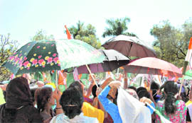 Congress workers at a rally in Dehradun on Friday use umbrellas to save themselves from the scorching heat 