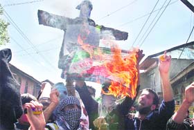 Protesters burn the National Flag during an anti-poll protest in Srinagar