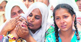 The wife and kids of Gurnam Singh, who died under mysterious circumstances in jail, seek justice in front of the district jail in Karnal on Saturday.