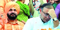 Im tired of it: BJP leader Arun Jaitley holds his head as Navjot Singh Sidhu looks on during a rally in Amritsar