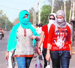 Beating the Heat: Girls try to cover their face on a hot afternoon in Gurgaon on Sunday.