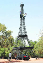Visitors enjoy a bird’s eye-view of the City Beautiful from atop a model of the Eiffel tower opposite the museum in Leisure Valley, Sector 10, on Monday. Climbing the tower is banned. Another city resident has parked his car under the shade of the tower to escape the heat.
