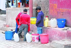 Children in Chakrata line up for water