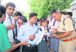 Traffic policemen check the papers of a young rider in Dehradun