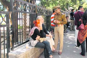 A police officer asks foreign tourists not to smoke at a public place