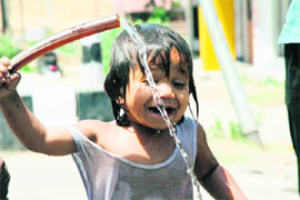 A child plays with water in scorching heat in Jammu.
