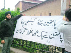 Green Dream members put up a banner at the Jamia Masjid in Srinagar, urging people to avoid the use of polythene