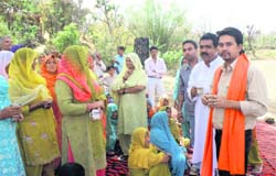 BJP candidate from Hamirpur parliamentary constituency Anurag Thakur interacting with women in a remote village in Kangra district during his election campaign