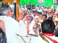Haryana Chief Minister Bhupinder Singh Hooda waves to the crowd from his Vijay Rath during his road show in the Sirsa parliamentary seat on Wednesday