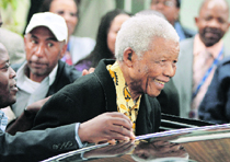 Former South African President Nelson Mandela smiles as he leaves after casting his vote in Houghton.