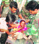 In this photograph released by the Sri Lankan military on Wednesday, army personnel tend to a child at a camp in northern Sri Lanka where people are staying after fleeing no-fire zone, an area controlled by the LTTE