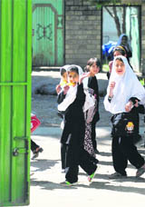 Afghan schoolgirls wave to German armed forces in Taloqan, east of Kundus, on Thursday