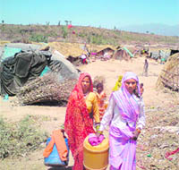 Sunehri, a slum dweller of the Jalla road, along with her neighbour going to fetch water near Burj village in Panchkula on Friday.