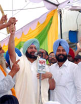 Capt Amarinder Singh raises an unsheathed sword during an election rally at Nathana in the Bathinda parliamentary constituency on Sunday.
