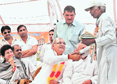 Chief Minister Bhupinder Singh Hooda shakes hands with one of his supporters while Congress candidate for the Ambala Lok Sabha seat Selja looks on at a rally in Barwala, Panchkula, on Sunday.