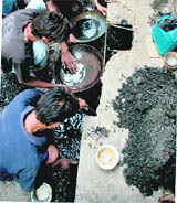 Workers search for gold ornaments burnt in a fire in a jewellery showroom at Jammu on Sunday