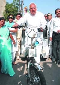 Congress candidate from Chandni Chowk Kapil Sibal pedals a solar-powered cycle-rickshaw during his campaign in the area