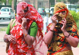 Women protect themselves from dusty wind and scorching heat in New Delhi