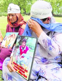 The mother of a missing youth wipes her tears during a silent protest in Srinagar