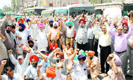 Employees of various departments block traffic to press for early implementation of Sixth Pay Commission in Amrisar on Tuesday.