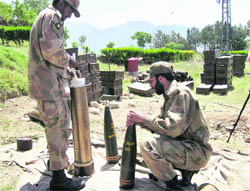 Pakistani troops fix fuses on heavy artillery at their post on the outskirts of Timargarh in Pakistan where security forces launched an operation against militants on Tuesday. 