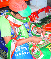 A man selling flags and posters of various parties in Dehradun.