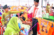 A boy distributes flags during a SAD rally in support of Daljeet Singh Cheema in Kharar on Wednesday.