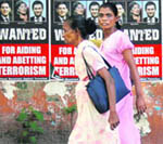 Pedestrians walk past posters that accuse British Foreign Secretary David Miliband, US Secretary of State Hillary Clinton and Norweigan politician Eric Solheim of aiding the Tamil Tiger rebels, on a main street in central Colombo on Wednesday.