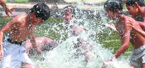 Boys play in water to beat the heat.