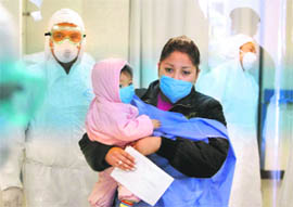 Wearing a protective face mask, a woman leaves with her child from the emergency area where people with swine flu-like symptoms are being checked at the Naval Hospital in Mexico City on Wednesday. 